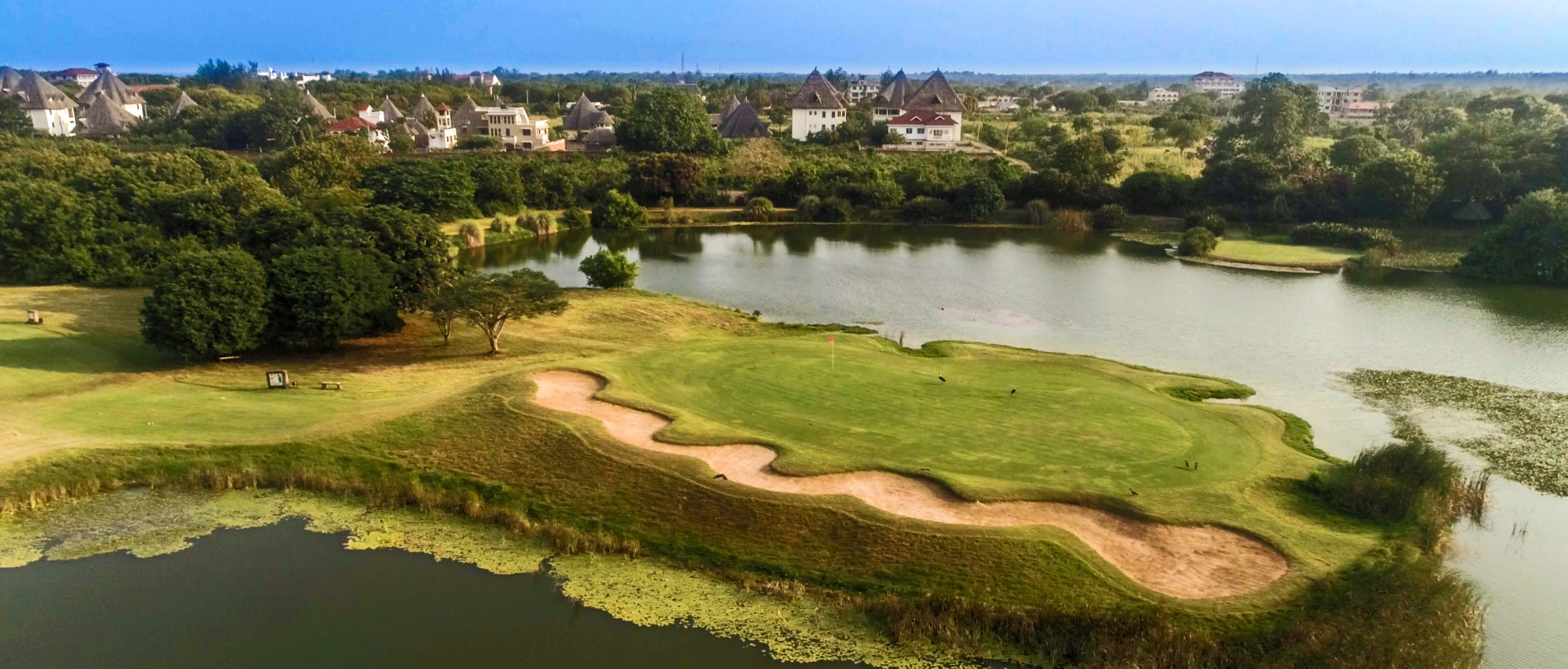 grüne golfanlage mit sandlöchern und einem großem see des Alfajiri Villas hotel in kenia