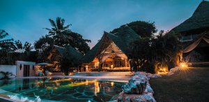 großer, beleuchteter pool einer traditionell gestalteten garden villa des Alfajiri Villas hotels bei dämmerung