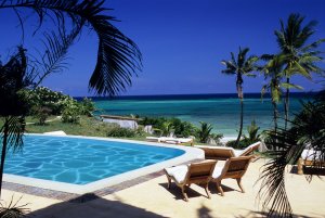 großer pool umgeben von palmen und bequemen sonnenliegen mit blick auf das meer im Alfajiri Villas hotel in kenia