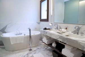 luxuriöses badezimmer aus hellem marmor mit freistehender badewanne und großem spiegel in der ambassadeur suite des Algodon Mansion hotel in argentinien