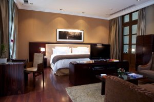 elegantes schlafzimmer der ambassadeur suite des Algodon Mansion hotel in argentinien mit luxuriösen elementen aus dunklem holz 