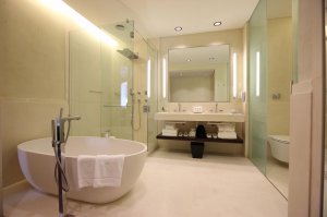 luxuriöses marmorbadezimmer mit großer freistehender badewanne und großer regendusche