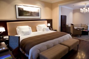 elegantes doppelbett der imperial suite des Algodon Mansion hotel in argentinien mit hellen textilien und geschmackvollen kunstwerken