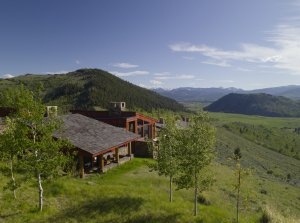 Blick auf das Aman Amangani East Tatanka Home eingebettet in herrlicher Natur umgeben von mächtigen Bergen in Wyoming USA