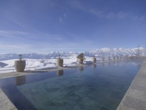 Blick über den Infinity Pool und das Bergpanorama im Aman Amangani Luxusresort in Wyoming USA im Winter