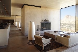 Restaurant und Lounge Bereich im Aman Amangiri mit offenem Kamin, sitzmöglichkeiten und großen Fenstern die den Blick auf die Wüste von Utah frei geben