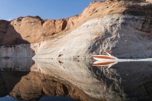 Schnellboot auf dem spiegelglatten Wasser direkt vor der imposanten Felsenkulisse in Utah