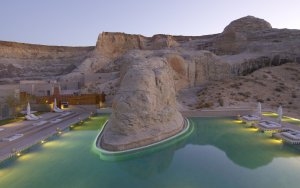 großer Pool des Aman Amangiri luxuriös beleuchtet in der Abenddämmerung direkt vor der imposanten Felsenkulisse in Utah