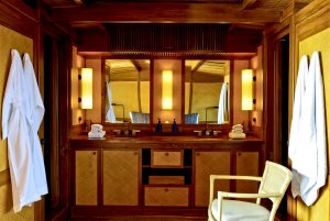 gemütliches bad direkt in der master cabin ensuite auf dem luxusschiff amanikan mit doppelwaschbecken und holzvertäfelung