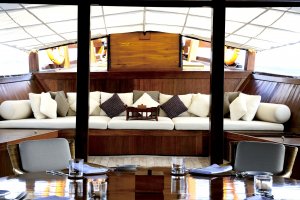 gemütliche lounge mit weißen polstern und vielen kissen an bord des luxus schiffes amanikan von aman mit blick auf den ozean