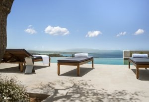 Blich über den Pool einer 5 Zimmer Villa des Amanzoe an dem Liegen und ein einmaliger Ausblick in die Landschaft warten Luxusresort Griechenland