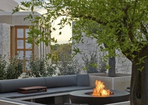 Der BBQ Bereich in einer 9 Betten Villa im Amanzoe mit schwarzem Sofa und Design-Grillstation