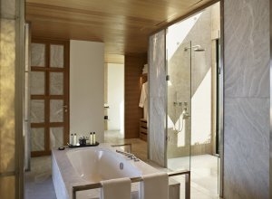 Das helle Badezimmer einer Neunraum Villa im Amanzoe mit hellem Marmor und viel Glas