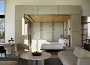 Schlafzimmer einer 9 Zimmer Villa im Amanzoe in hellen Stoffen und hellen Steintönen gehalten im Hintergrund das große Bett