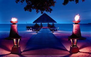 idyllischer steg mit fackeln beleuchtet im luxus resort angsana resort & spa ihuru im kaafu atoll malediven indischer ozean