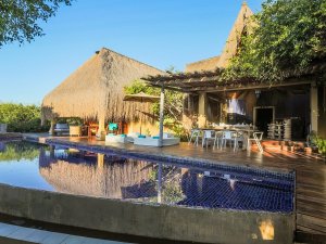 pool mit sonniger terasse und gemuetlichen liegen von einem bungalow mit viel holz im azura benguerra island in mosambik afrika