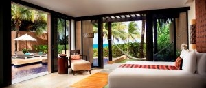 Luxusurlaub Mexiko im Banyan Tree Mayakoba das Schlafzimmer in hellen Farben gehalten mit Blick direkt auf den tollen Garten und das Meer in der Oceanfront Three Villa Poolvilla