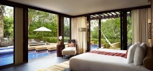 Luxusurlaub Mexiko im Banyan Tree Mayakoba Schlafzimmer in hellen Farben mit Blick auf den eigenen Pool einer Spa Poolvilla und großen Fenstern die das Licht ins Zimmer lassen und einen tollen Blick eröffnen