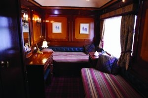 Blick in das luxuriöse Schlafabteil des Belmont Royal Scotsman mit viel edlem Holz und exclusiven Möbeln