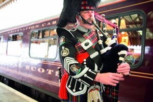 Der Belmont Royal Scotsman Luxuszug im Bahnhof davor ein Schotte mit Dudelsack