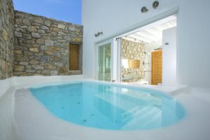 großer privater innenpool auf der terrasse des badezimmers in der privaten luxus villa big blue beach villa auf mykonos unter dem nachthimmel mit beleuchtetem bad