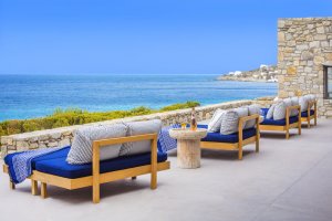 ausblick auf das meer auf der sonnen terrasse der privaten luxus villa big blue beach auf mykonos mit gemütlichen sonnenbetten unter strahlend blauem himmel
