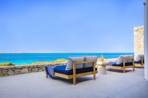 ausblick auf der terrasse der big blue beach villa von my private villas auf mykonos mit blick auf das blaue meer und gemütlichen sonnenliegen