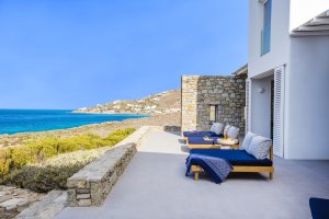 große terrasse der privaten villa big blue beach von my private villas auf mykonos mit meerblick und gemütlichen sonnenbetten an der küste