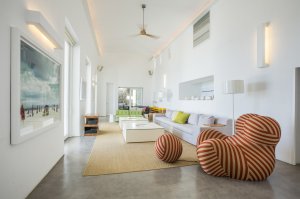 großer heller und hoher wohnraum in der privaten luxus villa auf mykonos mit heller einrichtung und modernen sitzmöglchkeiten vor großen fenstern