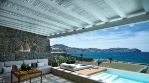 große Terrasse und Lounge mit Blick aufs Meer und die Küste am privaten Pool einer Honeymoon Coast Suite im Bill & Coo Leading Hotels of the World Mykonos Griechenland