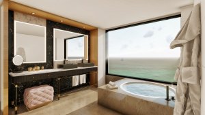 helles badezimmer mit großer runden whirlpool badewanne vor einem panoramafenster das direkt zum mittelmeer die aussicht freigibt