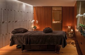 gemütliche liege für massagen im luxus hotel bulgari dubai in warmen farbtönen und kerzen schaffen eine behagliche athmosphäre