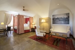 eine weitere Suite der Luxus Festung Mallorca Cap Rocat Spanien in rot Tönen gehalten mit viel Stein und gemütlichen Möblen