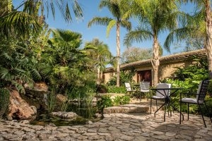 gemütlich gestaltete terrasse der garden suite mit palmen umgeben und ruhigen ecken durch pflanzen geschützt im burg hotel castell son claret