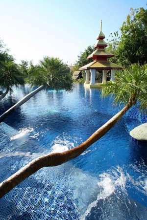 schöner pool und palmen im dhara dhevi in chiang mai thailand