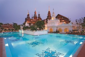 traumhafter pool am abend mit blick auf den tempel im dhara dhevi in chiang mai thailand