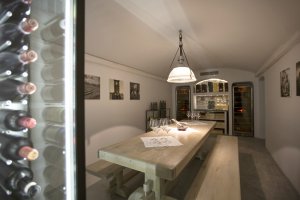 moderner essbereich in der privaten villa erosantorini mit eigenem weinvorrat und großem esstisch für einen traumurlaub auf santorin