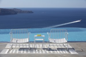 zwei stühle am pool mit blick auf das mittelmeer auf santorin auf der terrasse der privaten luxusvilla erosantorini