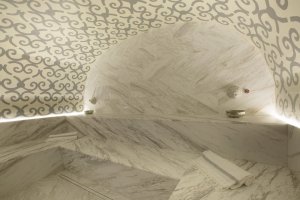 dampfbad mit marmorwänden und gemütlicher beleuchtung in der luxusvilla erosantorini im eigenen wellnessbereich der privaten villa
