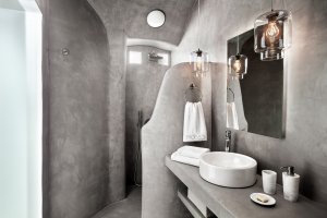 hellgraues modernes badezimmer in der privaten villa erossea auf santrorini mit runder dusche und modernem luxus waschbecken für einen traumurlaub in der privaten villa