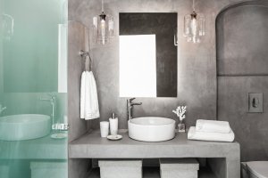 waschtisch im modernen bad der villa erossea in grautönen und strahlend weißen handtüchern auf dem geradlinigen waschtisch mit moderner einrichtung