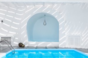 nahaufnahme des pool in der luxus villa erossea auf santorini mit heller weißer kalkwand im typisch griechischem design