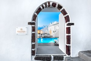 eingangsbogen der privaten villa erossea auf santorini mit strahlend weisser wand gibt den blick auf den modernen und luxuriösen pool auf der terrasse der villa frei