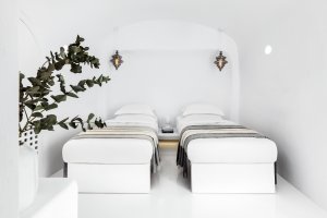 blick auf zwei nebeneinander liegenden spa betten in einem hellen weißen raum des privaten spa in der luxus villa erossea auf santorini
