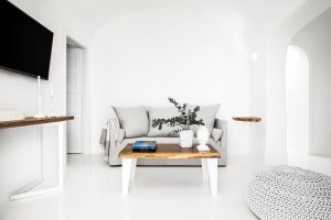 helles und minimalistisch eingerichtetes wohnzimmer in der modernen luxusvilla erossea mit sofa und tv für einen entspannten luxusrulaub in der eigenen villa