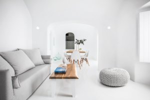 helles und modernes wohnzimmer der privaten villa erossea mit sofa und esstisch als minimalistische einrichtung in der luxusvilla auf santorini
