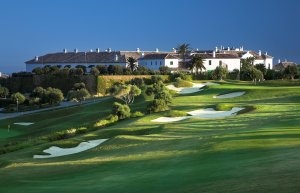 Golfplatz mit der Finca Cortesin im Hintergrund vor strahlend blauem Himmel an der Costa del Sol