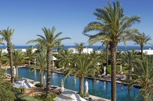 Großer mit Palmen umringte Pool der Finca Cortesin mit dem Mittelmeer im Hintergrund