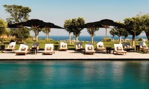 Blick über den großen Pool auf die bequemen Liegen am Mittelmeer an der Costa del Sol