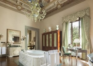 herrschaftliches Badezimmer mit antiken möbeln und freistehender badewanne und prunkvoller decke